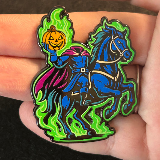 Headless Horseman enamel pin riding through Sleepy Hollow holding a jack-o’-lantern