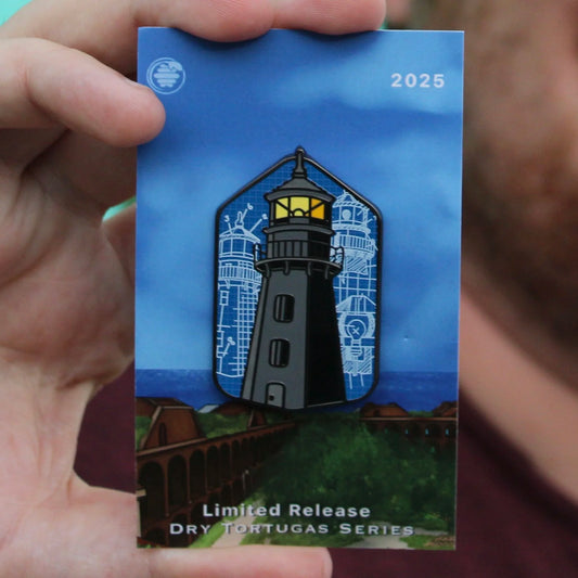 man holding pin hive pin of garden key lighthouse with backing card