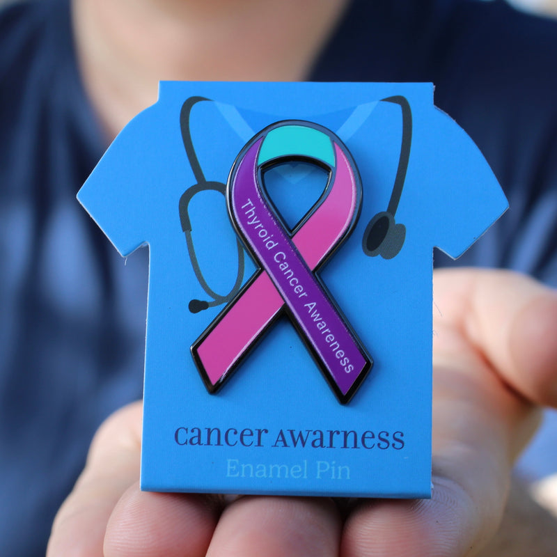 thyroid Cancer awareness enamel pin on a blue card held by a person