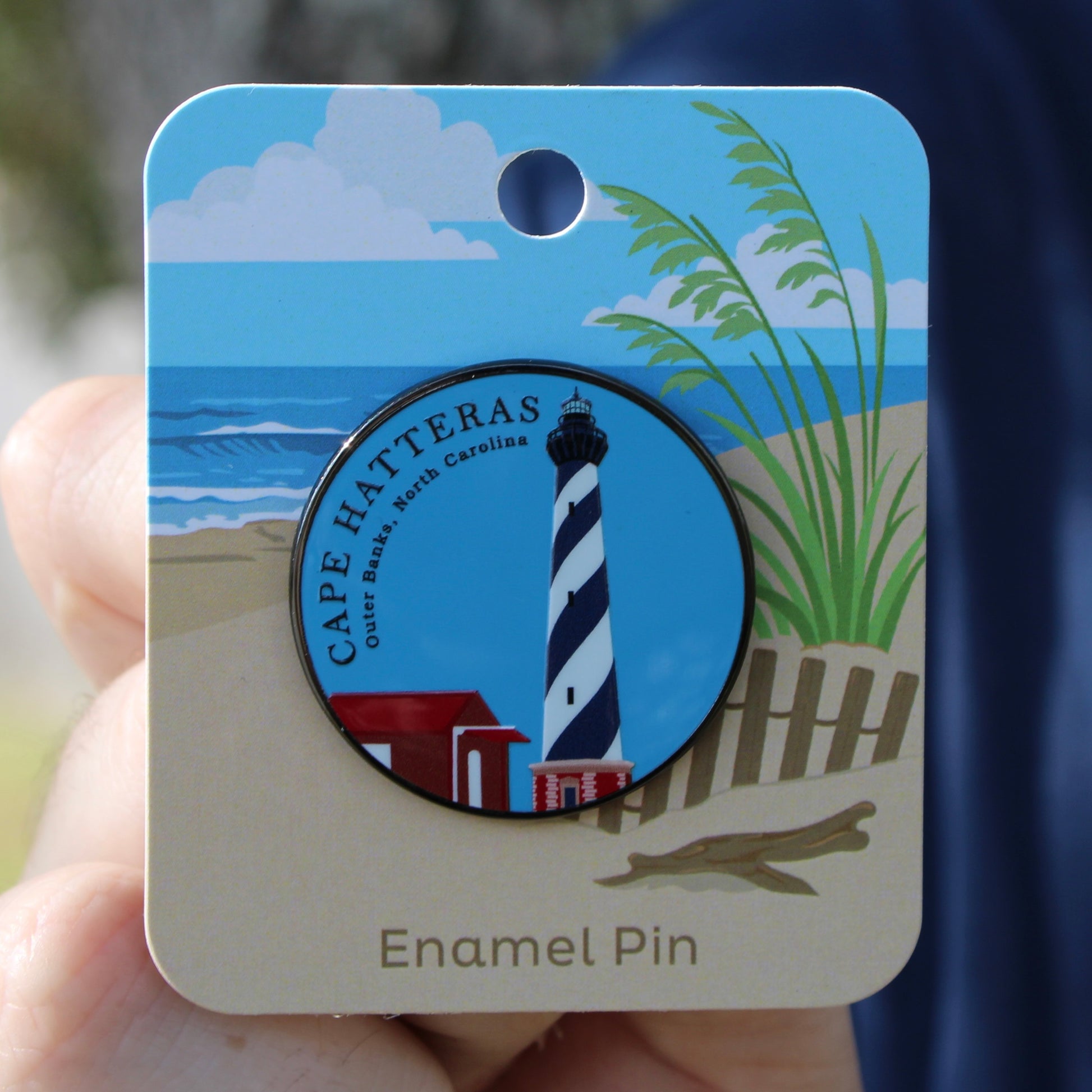 Cape Hatteras lighthouse enamel pin on a card with obx outer banks beach scenery