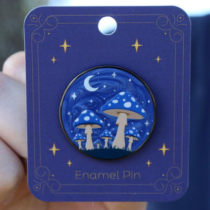 Blue enamel pin with mushroom forest design on a matching card