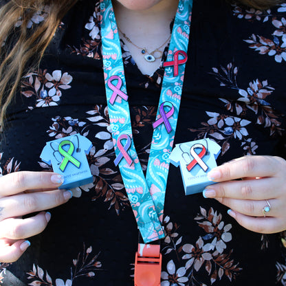 Person holding various cancer awareness pins 