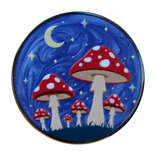 Decorative pin with red and white mushrooms on a white background